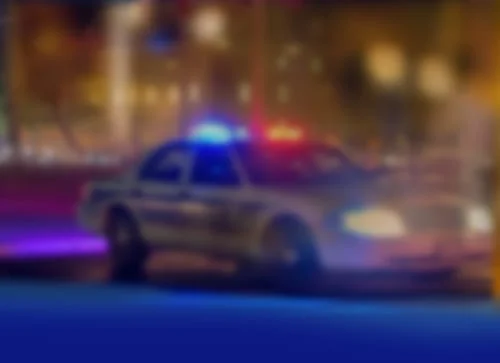 Law enforcement car with lights flashing in city